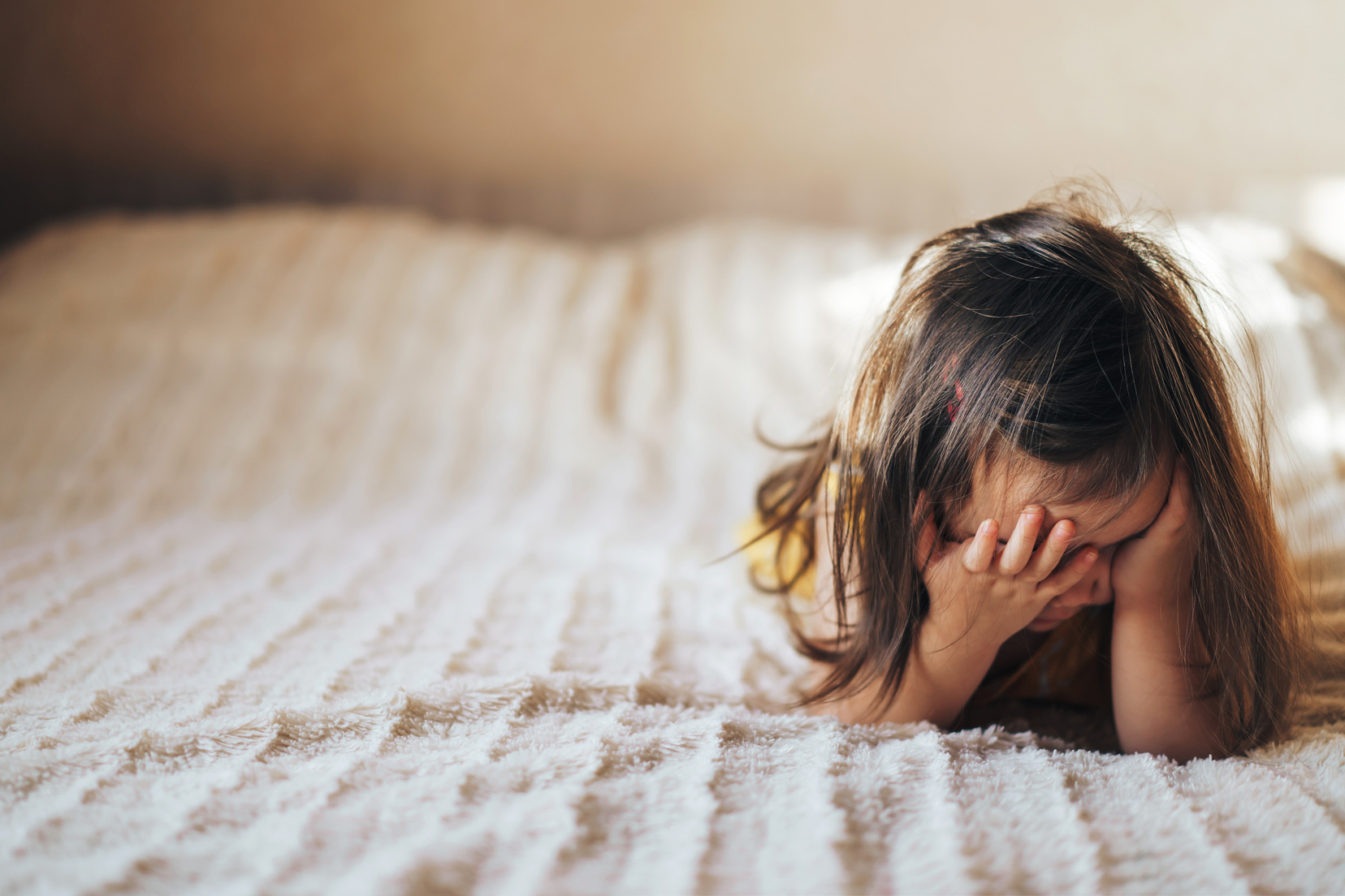 Upset Child Covers His Face with His Hands